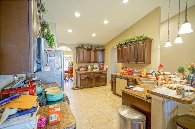 kitchen featuring lofted ceiling, a kitchen bar, hanging light fixtures, kitchen peninsula, and stainless steel appliances