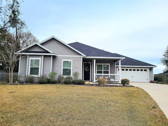 view of front of house featuring a garage, a porch, and a front lawn