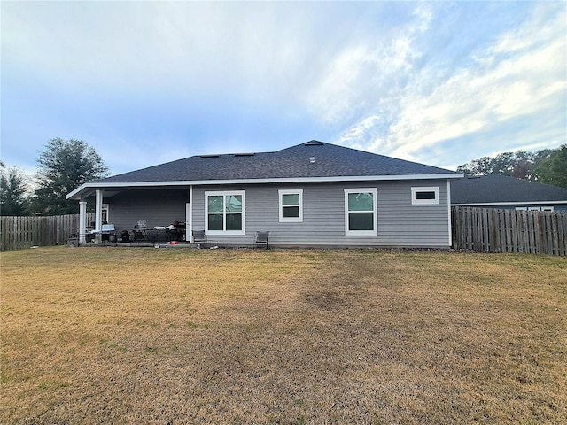 rear view of property featuring a yard