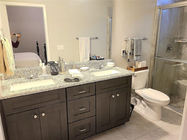 bathroom with tile patterned flooring, vanity, toilet, and an enclosed shower