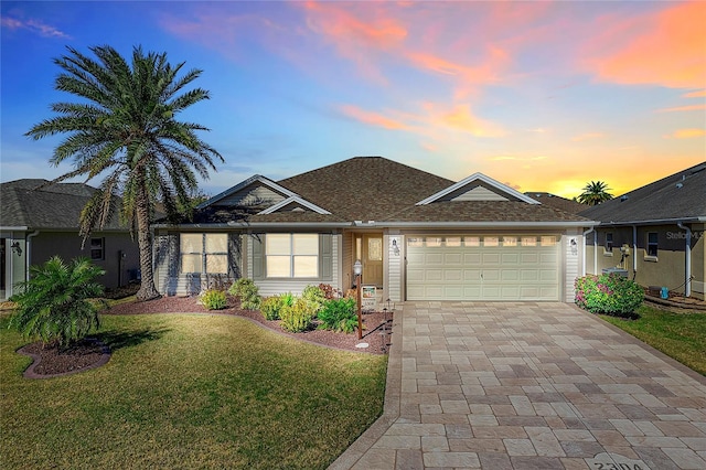 ranch-style home with a garage and a lawn