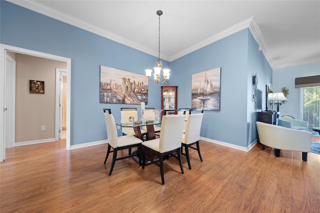 dining space featuring a notable chandelier, ornamental molding, and light wood-type flooring