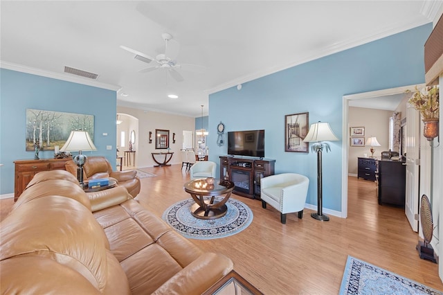 living room featuring crown molding, light hardwood / wood-style floors, and ceiling fan