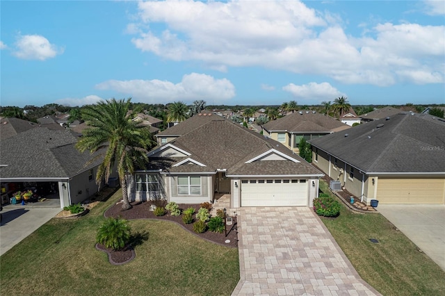 view of front of home featuring cooling unit, a garage, and a front yard