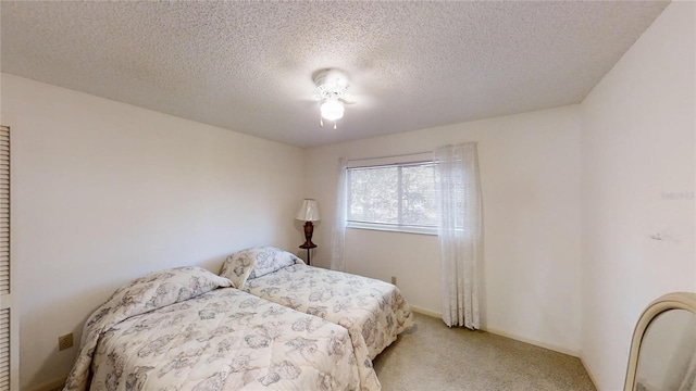 bedroom with light colored carpet and a textured ceiling