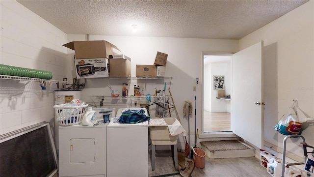 laundry area with washer and clothes dryer and a textured ceiling