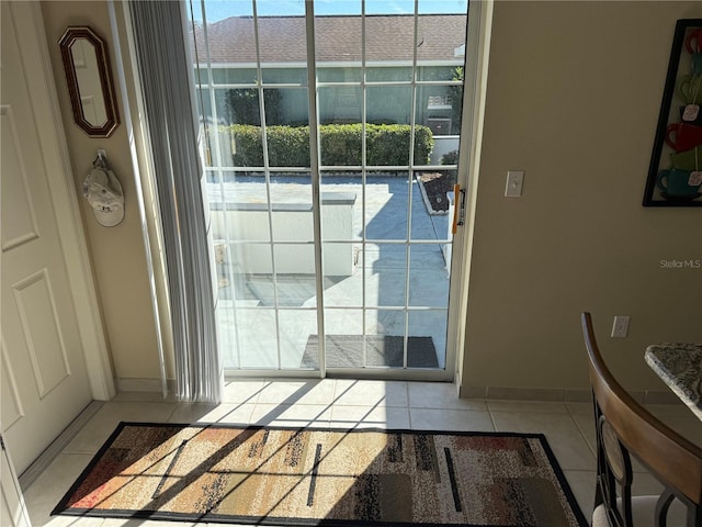 doorway to outside with light tile patterned flooring and plenty of natural light