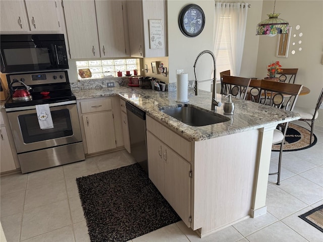 kitchen with sink, light tile patterned floors, stainless steel appliances, light stone counters, and light brown cabinetry