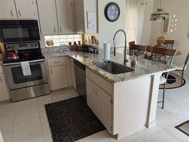 kitchen featuring light tile patterned flooring, appliances with stainless steel finishes, sink, light stone countertops, and light brown cabinets