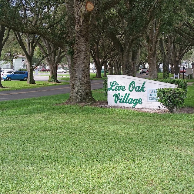 community / neighborhood sign featuring a lawn