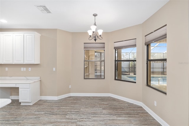 unfurnished dining area featuring a chandelier