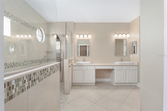 bathroom with tile patterned flooring, vanity, and a tile shower