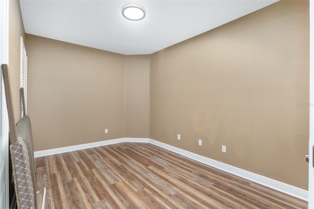 unfurnished room with wood-type flooring