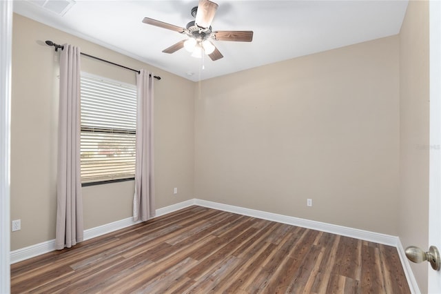 empty room featuring dark wood-type flooring and ceiling fan