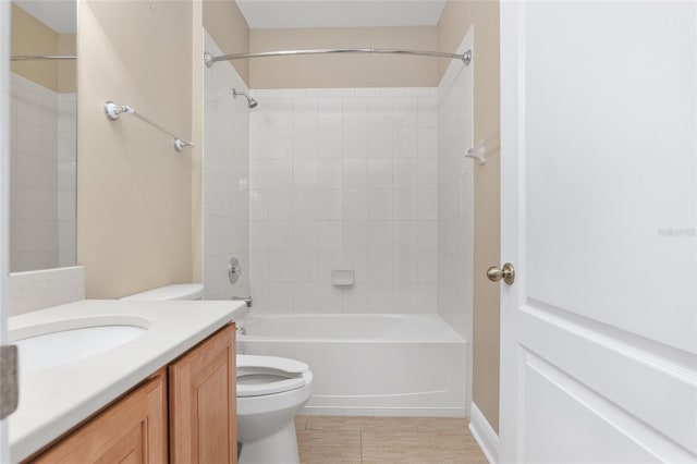 full bathroom featuring tile patterned flooring, vanity, tiled shower / bath, and toilet