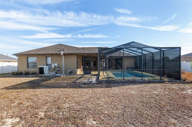 rear view of property featuring a fenced in pool, a lanai, a patio, and central air condition unit