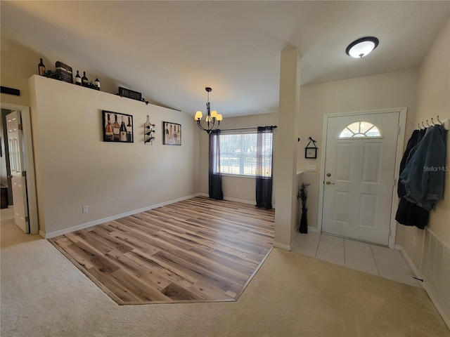 entryway with lofted ceiling, light tile patterned floors, and an inviting chandelier