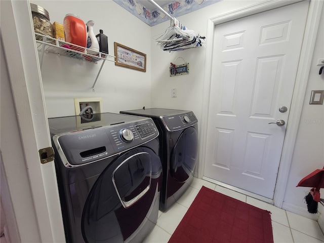 laundry room featuring washing machine and dryer and light tile patterned flooring