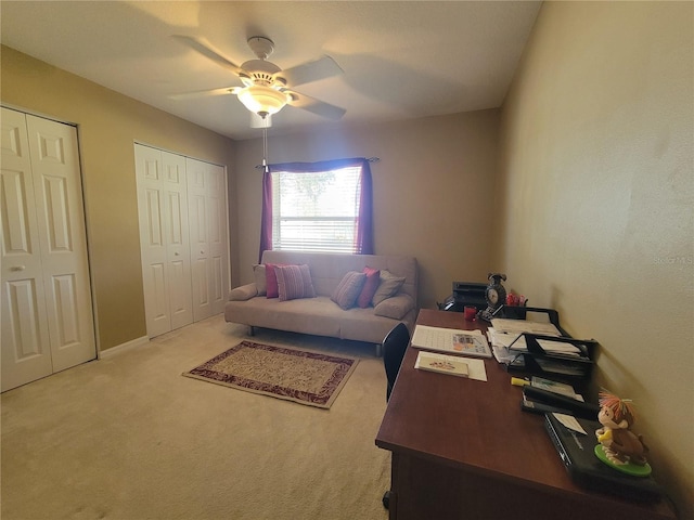 carpeted office space with ceiling fan