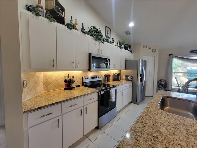 kitchen featuring lofted ceiling, sink, appliances with stainless steel finishes, decorative backsplash, and white cabinets