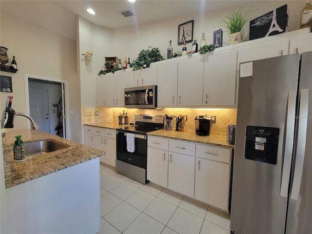 kitchen with white cabinetry, appliances with stainless steel finishes, sink, and backsplash