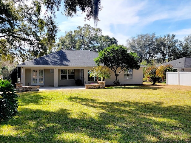 rear view of house with french doors and a lawn