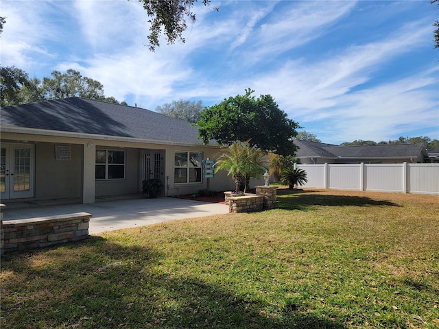 back of property featuring french doors, a yard, and a patio