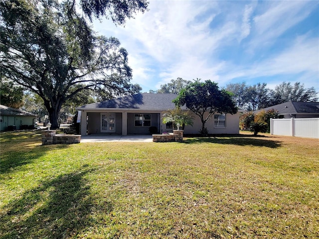 ranch-style house with a front lawn and a patio