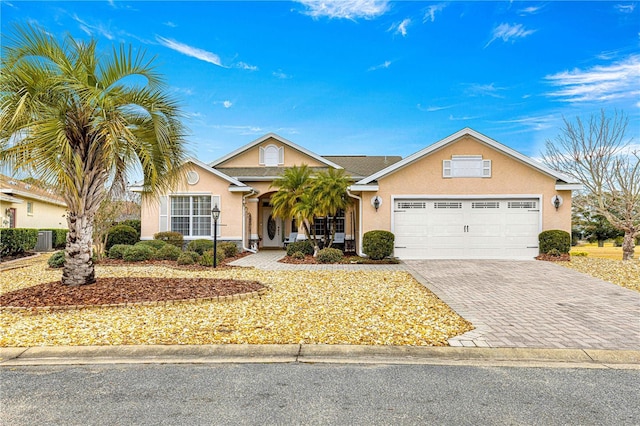 ranch-style home with a garage and central AC