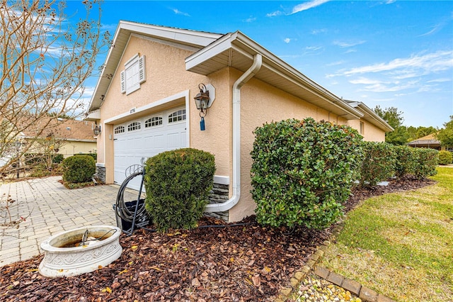 view of property exterior featuring a garage and a patio