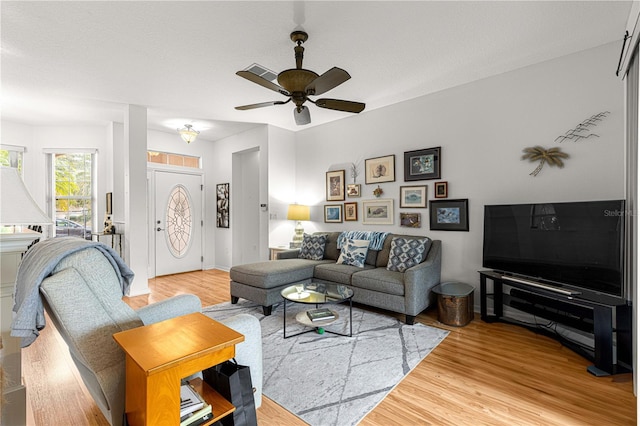 living room with wood-type flooring and ceiling fan