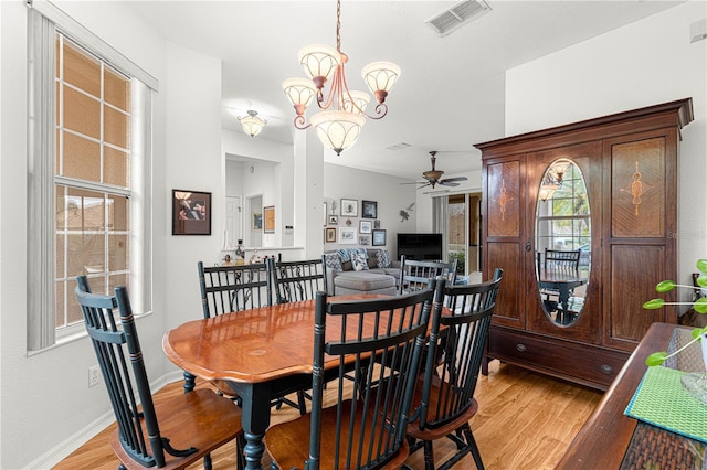 dining space featuring ceiling fan with notable chandelier and light hardwood / wood-style flooring