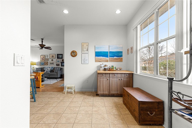 interior space with light tile patterned floors and ceiling fan