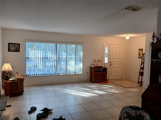 tiled foyer with a textured ceiling