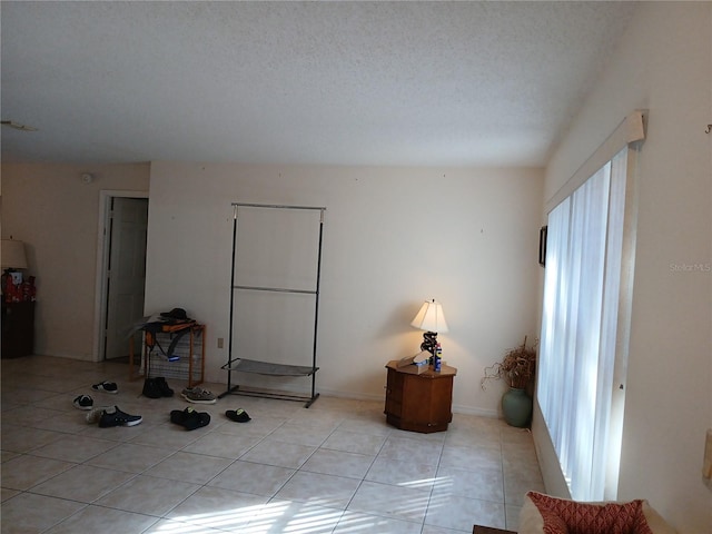 interior space featuring light tile patterned floors and a textured ceiling