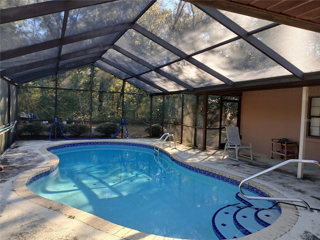 view of swimming pool featuring a patio and glass enclosure