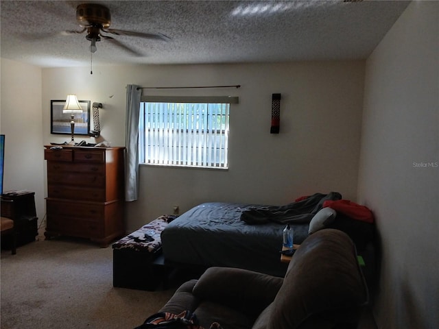 carpeted bedroom featuring ceiling fan and a textured ceiling