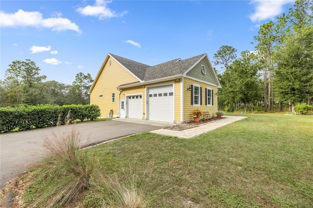 view of side of property with a garage and a lawn