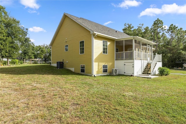 view of side of home with central AC, a yard, a sunroom, and ac unit