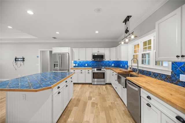 kitchen with white cabinets, decorative backsplash, a center island, stainless steel appliances, and crown molding