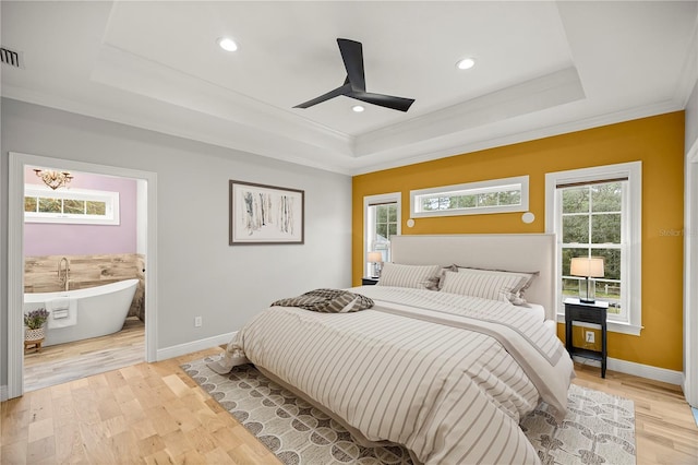 bedroom featuring a raised ceiling, light wood-type flooring, and ceiling fan