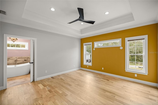 unfurnished bedroom with a raised ceiling, crown molding, ceiling fan, and light hardwood / wood-style flooring