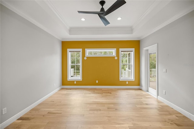 unfurnished room with a raised ceiling, crown molding, ceiling fan, and light wood-type flooring