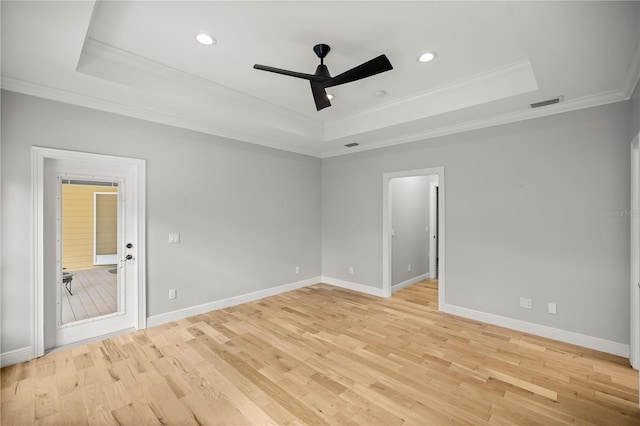 unfurnished room with crown molding, ceiling fan, a raised ceiling, and light hardwood / wood-style flooring