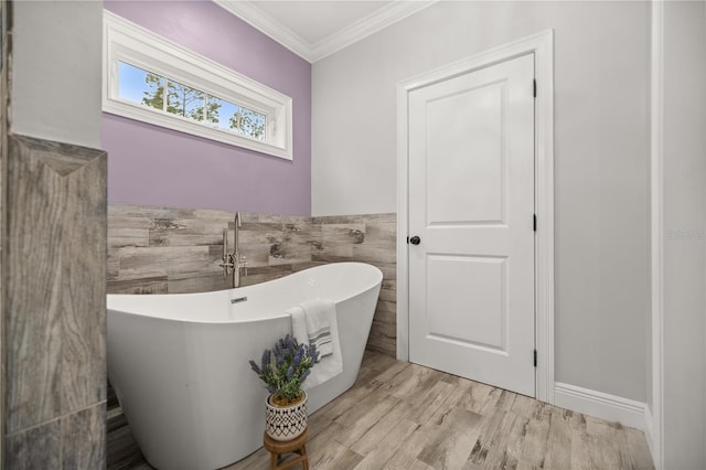 bathroom featuring hardwood / wood-style flooring, ornamental molding, and a bath