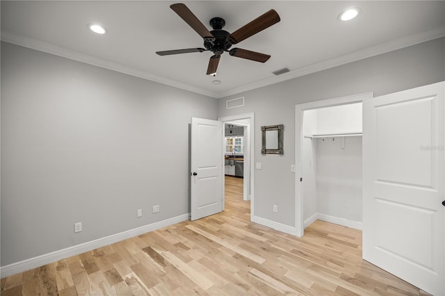 unfurnished bedroom featuring a spacious closet, ornamental molding, light hardwood / wood-style floors, and ceiling fan