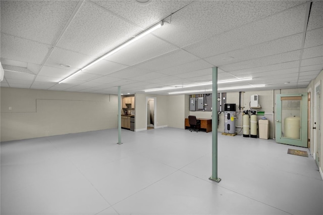 basement with a drop ceiling and electric panel