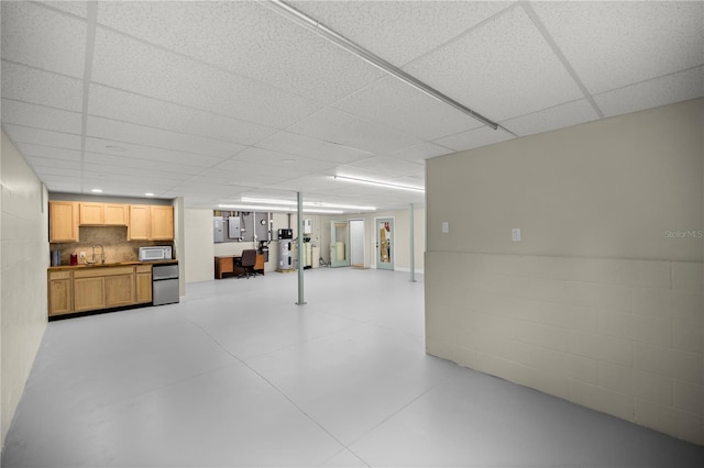 basement featuring water heater, sink, and refrigerator