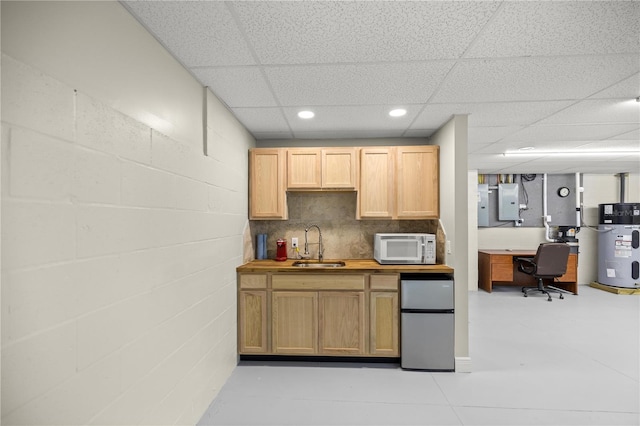 kitchen featuring wood counters, stainless steel refrigerator, sink, hybrid water heater, and electric panel