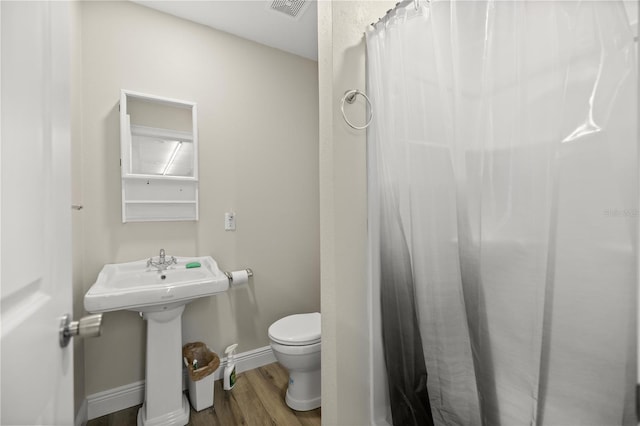 bathroom with sink, hardwood / wood-style flooring, and toilet